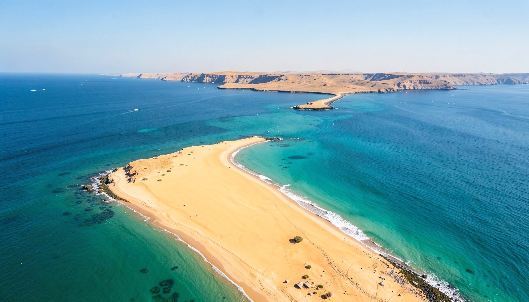 A sweeping aerial view of the Sinai Peninsula with golden sand meeting turquoise water, the light crisp and clear, evoking a sense of exploration.